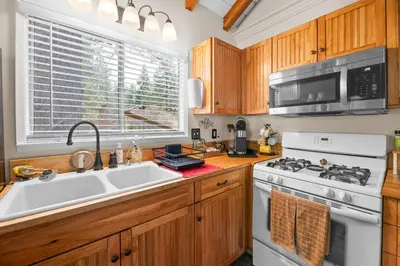a kitchen with a sink and a stove and a microwave at Bluebird Cabin, Indoor Fireplace, Next to Lake! in Green Valley Lake