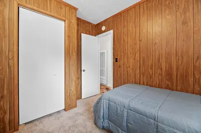 a bedroom with wood paneled walls and a bed at Bluebird Cabin, Indoor Fireplace, Next to Lake! in Green Valley Lake