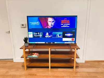 a flat screen tv sitting on a wooden stand at Boutique KTown Stays With Breathtaking Rooftop Views in Los Angeles
