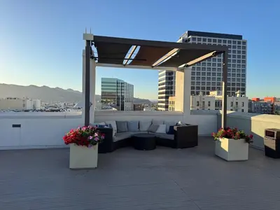 a rooftop patio with a couch and tables and flowers at Elegant & Charming 2BR Apartment in Glendale
