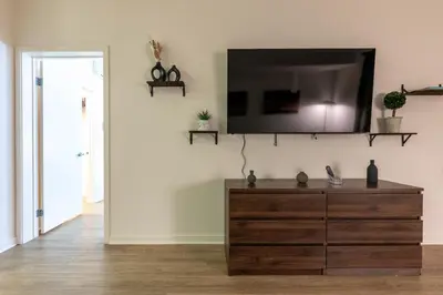 a living room with a dresser with a tv on the wall at Elegant & Charming 2BR Apartment in Glendale