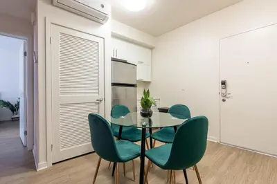 a dining room with a glass table and green chairs at Elegant & Charming 2BR Apartment in Glendale