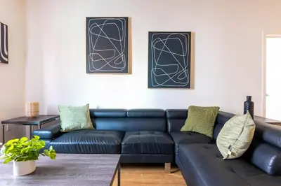 a living room with a black leather couch at Lovely and Modern Apartment in Glendale