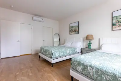a bedroom with two beds and a mirror at Lovely and Modern Apartment in Glendale
