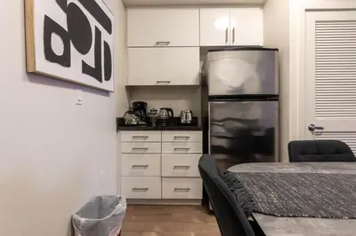 a kitchen with a refrigerator and white cabinets at Lovely and Modern Apartment in Glendale