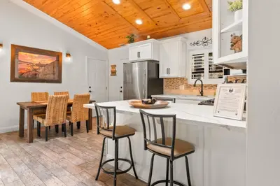 a kitchen with a counter with chairs and a table at Hummingbird Corner Pet Friendly Great Location Jacuzzi in Big Bear Lake