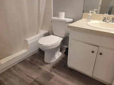 a white bathroom with a toilet and a sink at Great Location Double Queen Bed Unit in Los Angeles