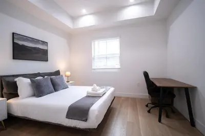 a white bedroom with a bed and a desk at Stylish Private Room by Downtown LA with Private Parking in Los Angeles