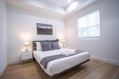 a white bedroom with a large bed and a window at Stylish Private Room by Downtown LA with Private Parking in Los Angeles