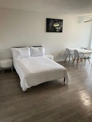 a bedroom with a white bed and a table and chairs at Hollywood Spectacular Loft FREE Designated parking in Los Angeles