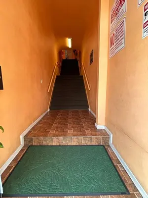 an empty hallway with a green floor in a building at Plaza Hotel Gardena in Gardena