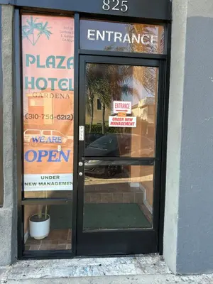 a door to a hotel with signs on it at Plaza Hotel Gardena in Gardena