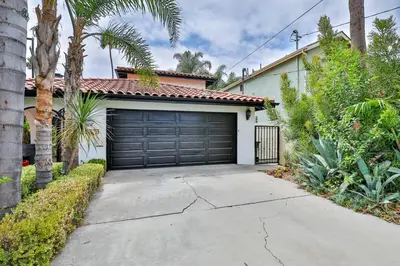 a garage door of a house with palm trees at Estate with Heated Pool & Jacuzzi & Tennis Court in Sherman Oaks Community Hospital Heliport