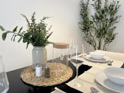 a table with wine glasses and a vase with flowers at Seabreeze Hideaway one bedroom in Los Angeles