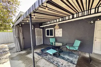 a patio with a table and chairs under awning at Walgrove Guest House in Los Angeles