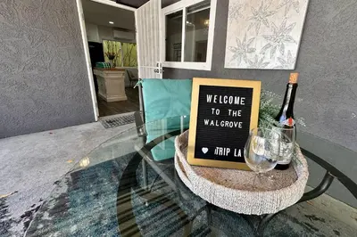 a table with a wine bottle and a sign on it at Walgrove Guest House in Los Angeles