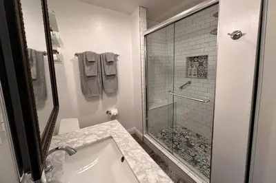 a white bathroom with a shower and a sink at Walgrove Guest House in Los Angeles
