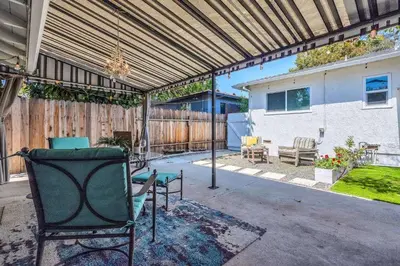 a patio with a pergola and chairs and a bench at Walgrove Guest House in Los Angeles