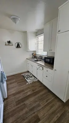a kitchen with a white refrigerator and a wooden floor at Spacious Silverlake Apartment in Los Angeles