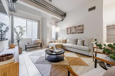 a living room with a couch and a table at Industrial Style 2BR Condo Downtown LA With Rooftop! in Los Angeles