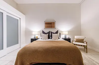 a bedroom with a large bed and a chair at Industrial Style 2BR Condo Downtown LA With Rooftop! in Los Angeles
