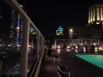 a night view of a building with a swimming pool at Industrial Style 2BR Condo Downtown LA With Rooftop! in Los Angeles