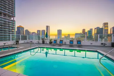 a swimming pool on top of a building with a city skyline at Modern Loft 1BR in Downtown LA! in Los Angeles