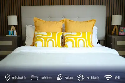 a bed with yellow and white pillows on it at 6BR 3BA Home near Disneyland in Anaheim