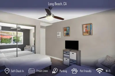 a bedroom with a bed and a flat screen tv at Chic 4B2B Townhome Private Pool in Long Beach