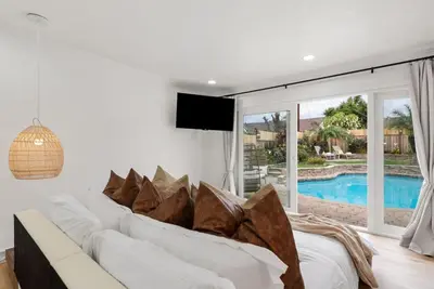 a living room with a white couch and a large window at Sunny Daze - Heated Pool - Billiards - Games in Placentia