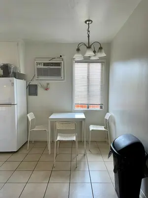 a kitchen with a table and chairs and a refrigerator at Riverton Place NoHo in Los Angeles