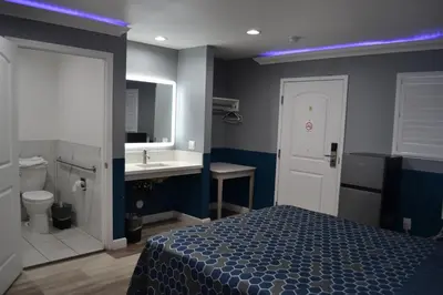 a bedroom with a bed and a bathroom with a sink at Villa Las Palmas Motel in Barton Heliport