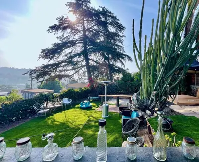 a table with glass bottles sitting on top of a yard at The Perch- Hilltop Bungalow, Eagle Rock-near DTLA in Los Angeles