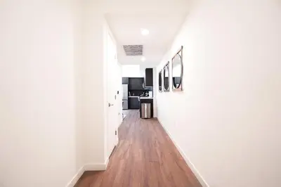 a hallway with white walls and a wooden floor at The Hollywood Highline 2 bed Apt WITH FREE PARKING in Hollywood in Los Angeles