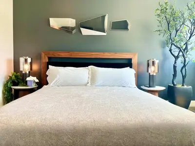 a bedroom with a bed with two lights on the wall at Penthouse 2 Bedroom with Hollywood Sign View! in Los Angeles