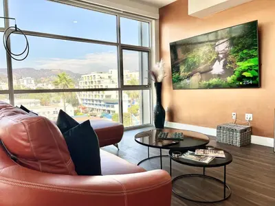 a living room with a couch and a large window at Penthouse 2 Bedroom with Hollywood Sign View! in Los Angeles
