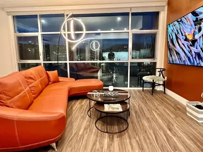 a living room with an orange couch and a table at Penthouse 2 Bedroom with Hollywood Sign View! in Los Angeles