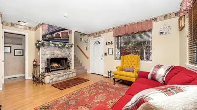 a living room with a red couch and a fireplace at Charming Cabin for Winter and Water Sports Fans Near Big Bear Lake, California in Arrowbear Lake