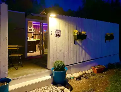 a small house with a porch at night at Fully Refurbished Container in Devore Heights, California, for Glamping Trips on Route 66 in Devore Heights