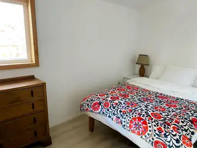 a bedroom with a bed and a dresser and a window at Stunning Cabin with Indoor Jacuzzi Ideal for a Weekend Getaway from Los Angeles in Pine Mountain Club