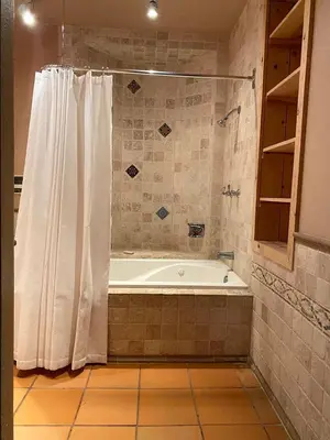 a bathroom with a tub and a shower curtain at Stunning Cabin with Indoor Jacuzzi Ideal for a Weekend Getaway from Los Angeles in Pine Mountain Club