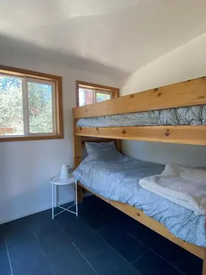 a bedroom with two bunk beds and a table at Stunning Cabin with Indoor Jacuzzi Ideal for a Weekend Getaway from Los Angeles in Pine Mountain Club