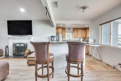 a kitchen with two bar stools in a living room at 8 Mi to Dtwn Home with Fireplace and Games in LA! in Los Angeles