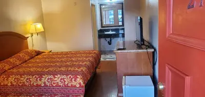a hotel room with a bed and a flat screen tv at El Rio Motel in Glendale