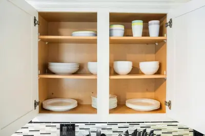 a cupboard filled with plates and bowls in a kitchen at Avengers HQ - Hot Tub - Close to Disney - Parking in Anaheim