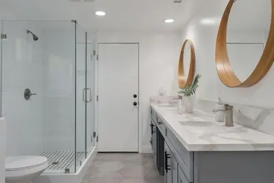 a bathroom with a shower and a toilet and a sink at Overlooking Luxury - Pool Heat - Spa - Games in Pico Rivera