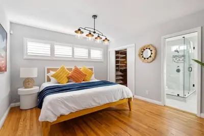 a bedroom with a bed with yellow and blue pillows at Splash Haven-Heated Pool-Huge Living Area-Sleeps 8 in Long Beach