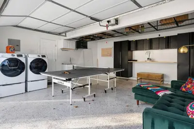 a living room with a ping pong table and washing machines at Splash Haven-Heated Pool-Huge Living Area-Sleeps 8 in Long Beach