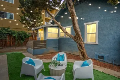 a yard with chairs and a tree with a house at Sunset Shores - Near the beach - Games - Sleeps 8 in Long Beach