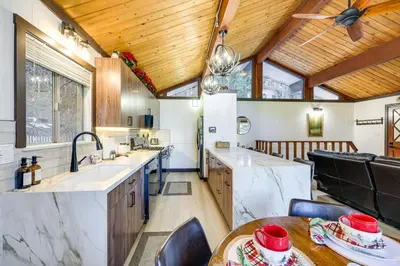 a kitchen with white counter tops and wooden ceilings at 3 Mi to Lake Arrowhead Village Pine-View Home! in Lake Arrowhead